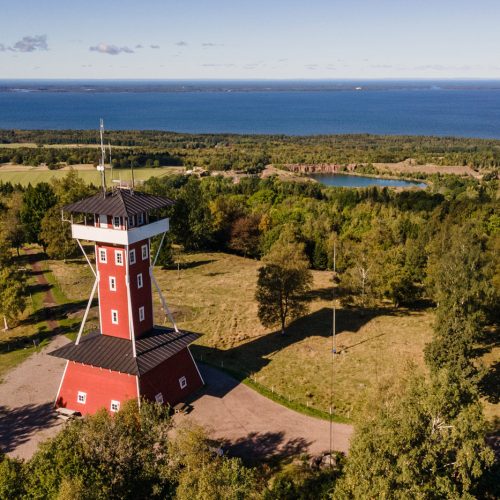 Vy från Högkullen på Kinnekulle med utsiktstornet i förgrunden. Stora stenbrottet och Vänern i horisonten.