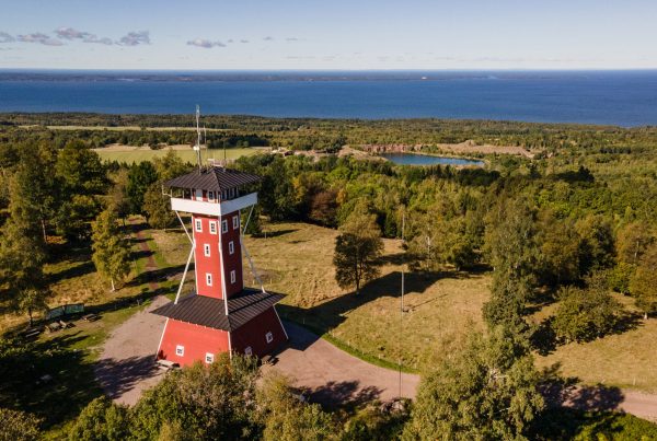 Vy från Högkullen på Kinnekulle med utsiktstornet i förgrunden. Stora stenbrottet och Vänern i horisonten.